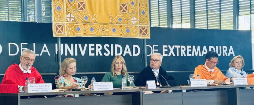 Doctores de la Universidad de Extremadura en la apertura del curso académico, sentados en una mesa durante el acto.